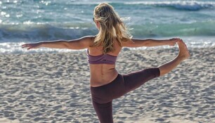 femme faisant du yoga sur la plage